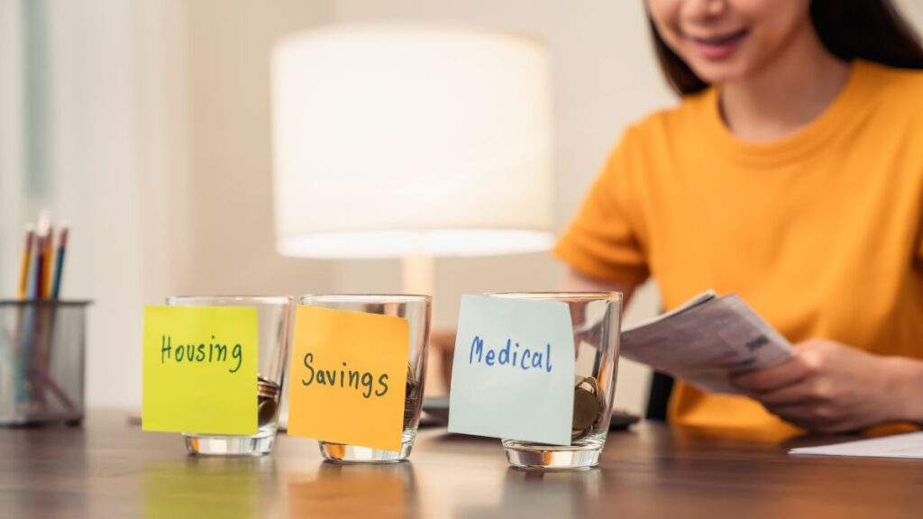 an individual separating cash into different budget categories for savings and expenses