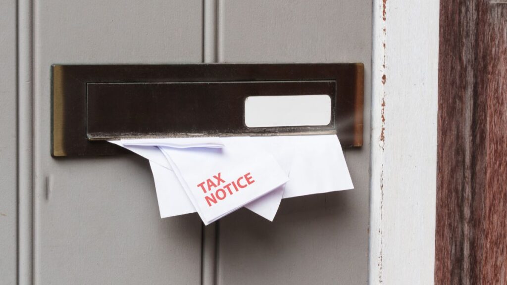 CRA notice letter in the mail with other documents representing post-tax season follow-up
